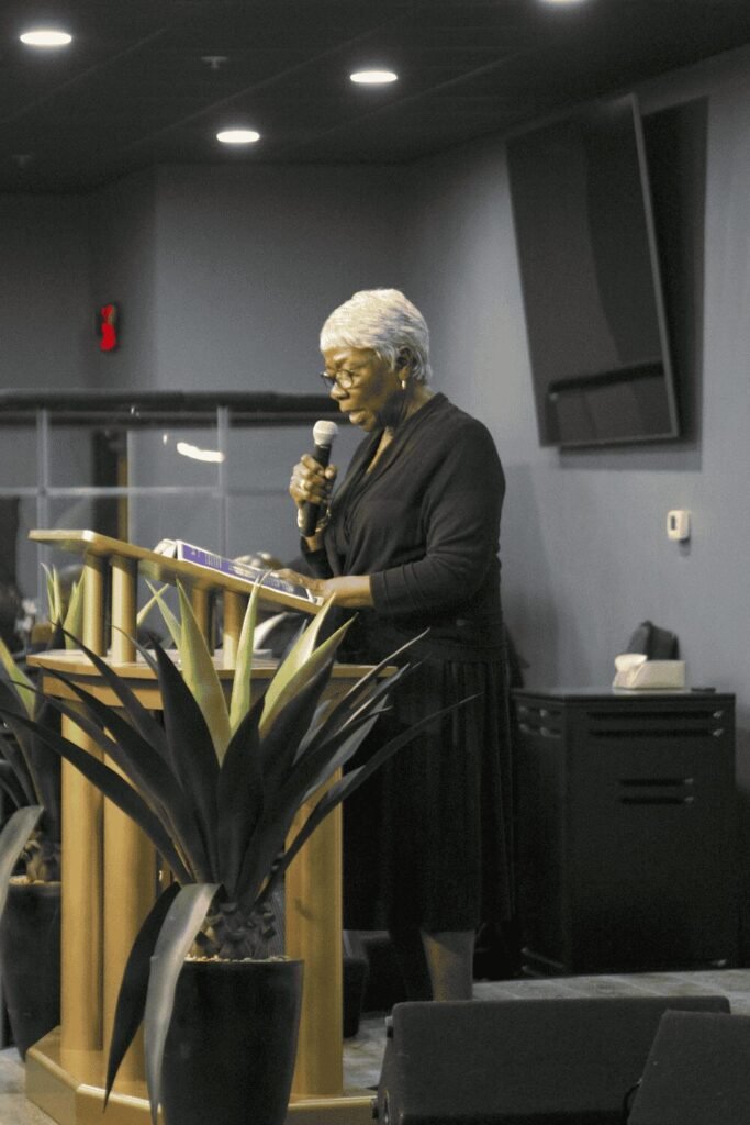 Mary reading scripture at the podium